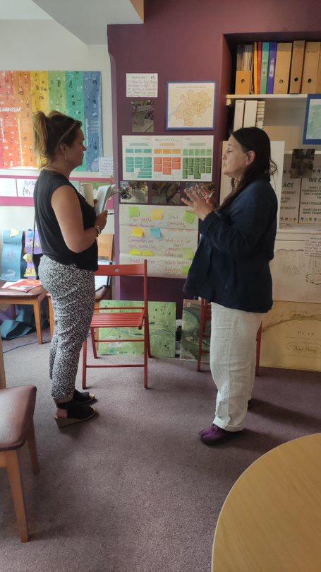 Two people in deep discussion, standing in front of some posters and charts 