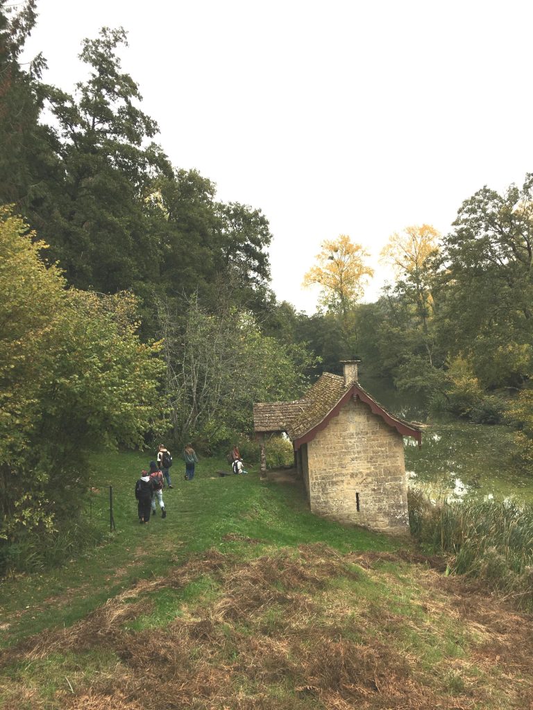 Some people near an old stone building in the countryside