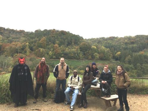 7 young people leaning on a stone wall