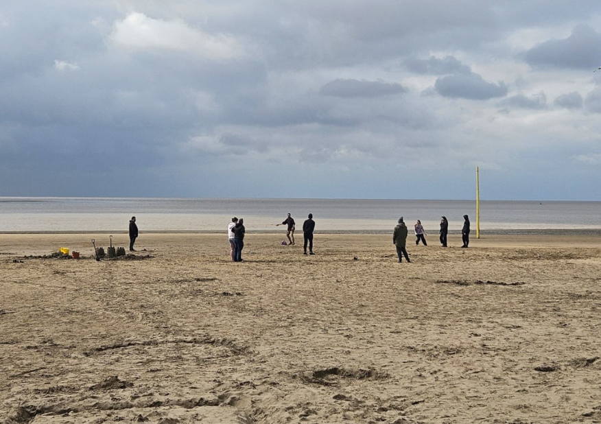 young people playing a ball game on a beach