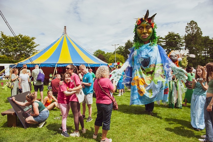 Giant walkabout puppet of Mother Earth by Artshape in a field with kids and a circus tent (image Andrea Fiodi)