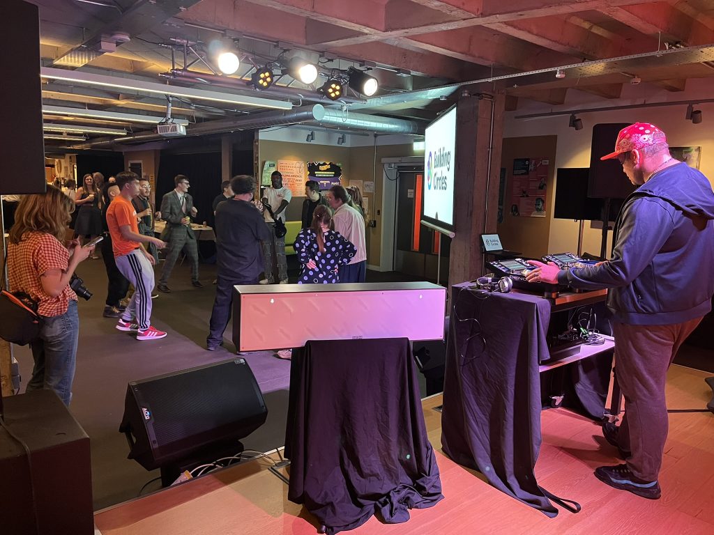 An image of a DJ and young people dancing